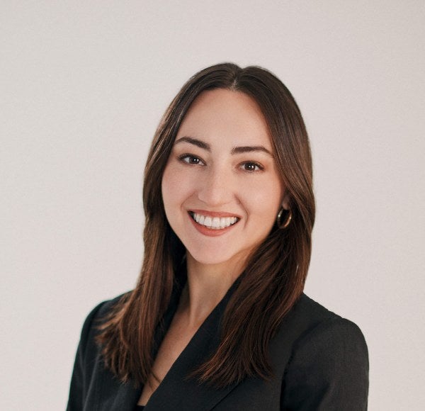 headshot of a woman wearing glasses in front of white background