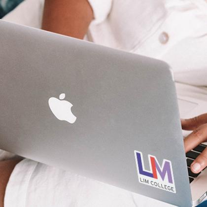 A laptop with LIM College sticker on it.