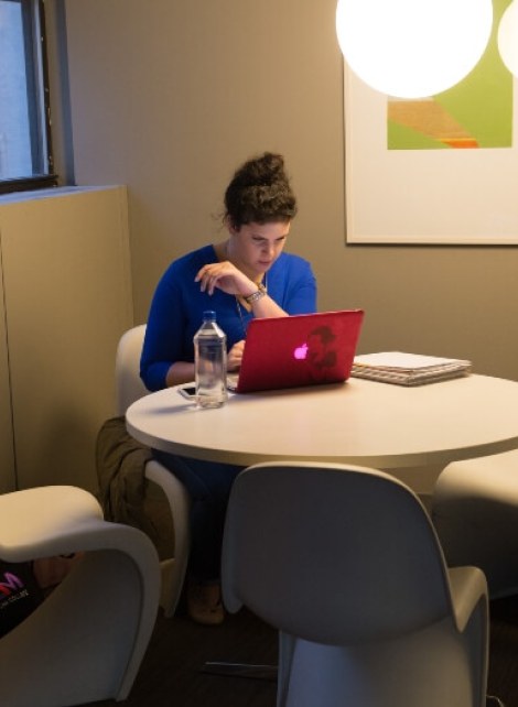 woman on laptop, blue shirt, water bottle