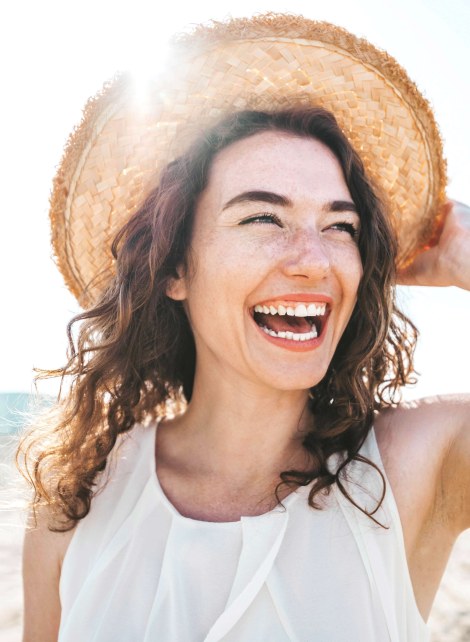 young woman in hat laughing 