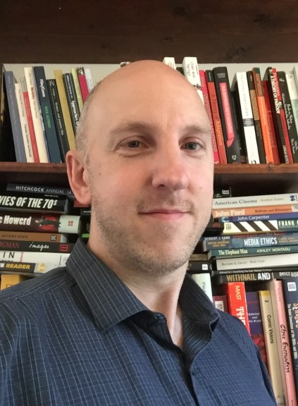 man standing in front of bookcase