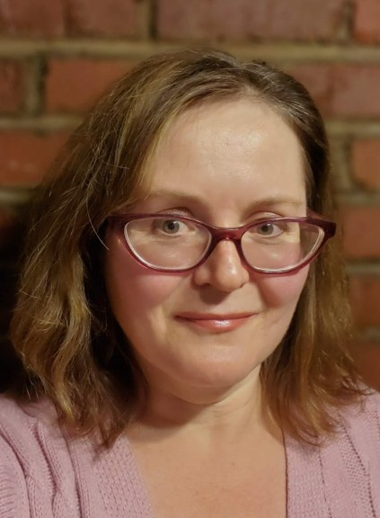 Selfie of a woman in front of brick wall 