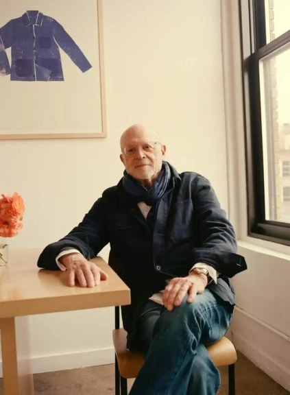 Mickey Drexler, dark jacket, jeans, seated in white room