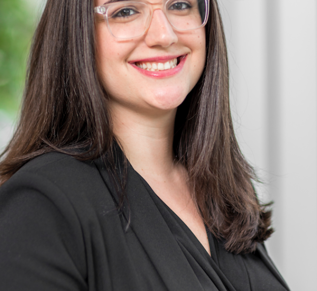 dark haired woman in glasses smiling