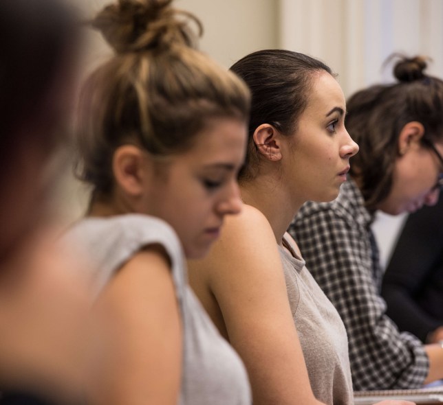 row of students in classroom, side angle