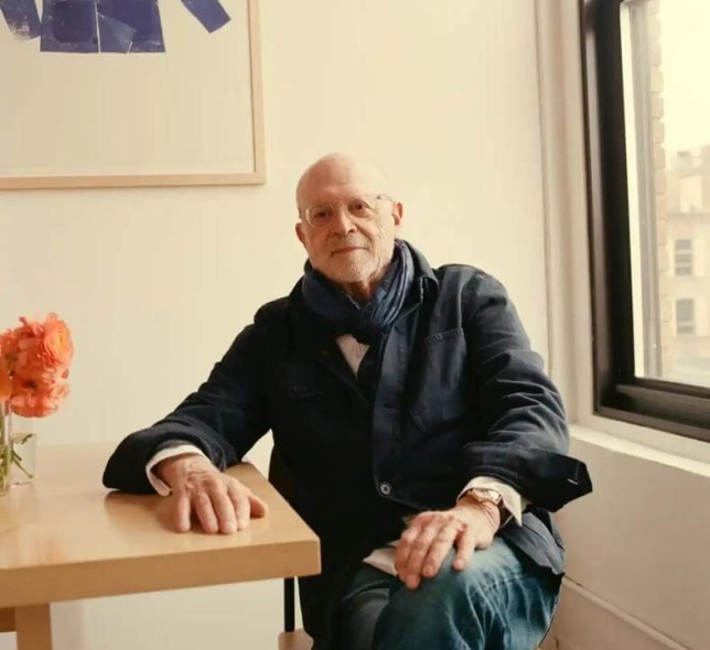 Mickey Drexler, dark jacket, jeans, seated in white room