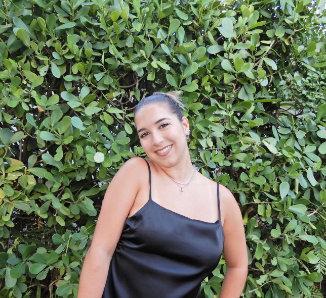 girl in front of shrubs