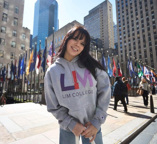 dark-haired young woman in LIM College hoodie, standing outdoors in Rockefeller Plaza