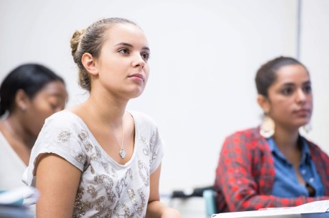 Three students in classroom, row desks