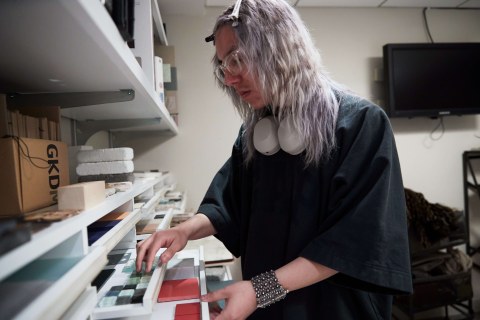 student with purple hair looking at material samples