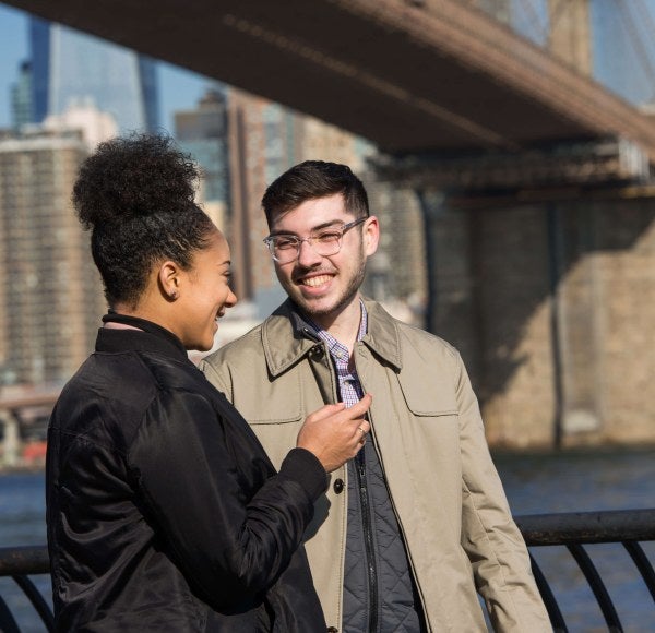 Two students talk at lower Manhattan promenade near the Brooklyn Bridge